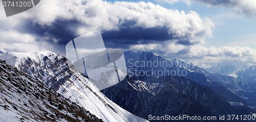 Image of Panoramic view on winter mountains in evening and cloudy sky