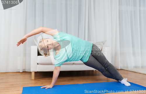 Image of woman exercising on mat at home