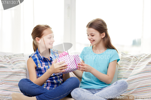 Image of happy little girls with birthday present at home