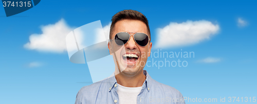 Image of face of smiling man in shirt and sunglasses