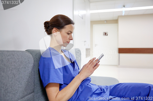 Image of female doctor or nurse with smartphone at hospital