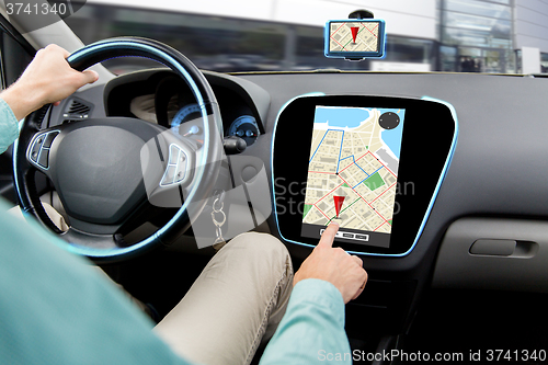 Image of close up of man driving car and using navigator