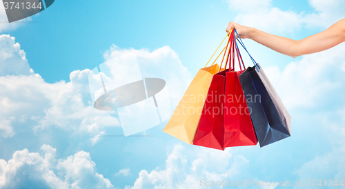 Image of close up of female hand holding shopping bags