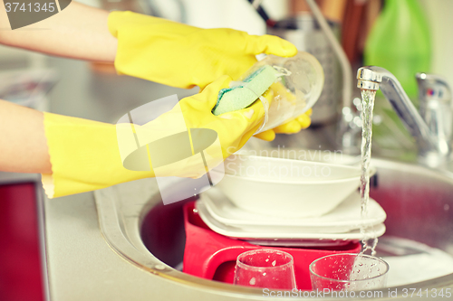 Image of close up of woman hands washing dishes in kitchen