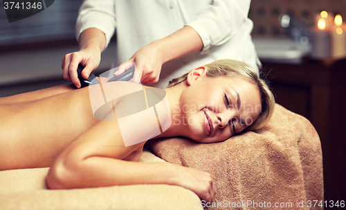 Image of close up of woman having hot stone massage in spa