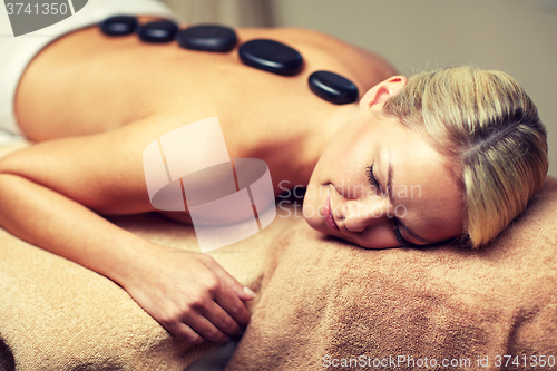 Image of close up of woman having hot stone massage in spa