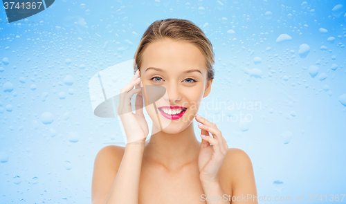 Image of smiling young woman with pink lipstick on lips