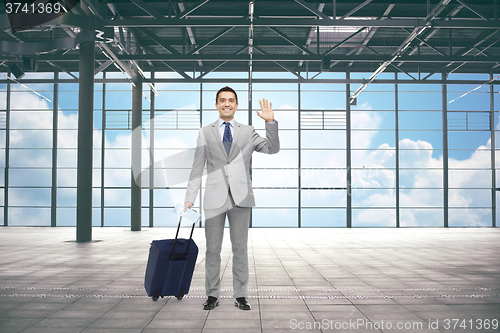 Image of businessman with travel bag and ticket at airport