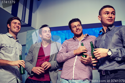 Image of group of male friends with beer in nightclub