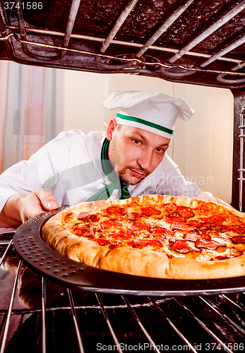 Image of Chef cooking pizza in the oven.