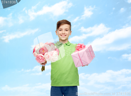 Image of happy boy holding flower bunch and gift box