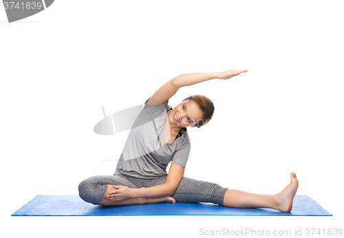 Image of happy woman making yoga and stretching on mat