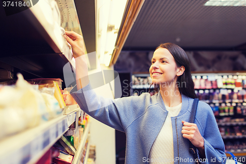 Image of happy woman choosing and buying food in market