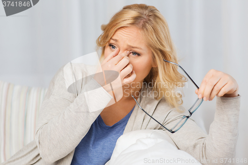 Image of tired woman taking eyeglasses offhome