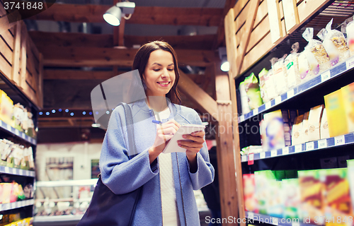 Image of happy woman with notepad in market