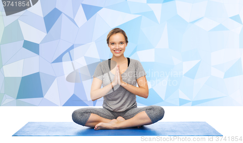 Image of woman making yoga meditation in lotus pose on mat