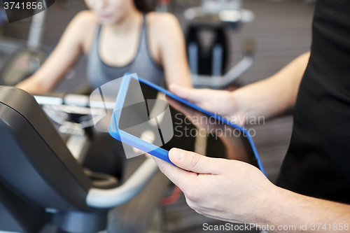 Image of close up of trainer hands with tablet pc in gym