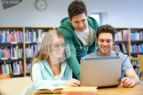 Image of happy students with laptop in library