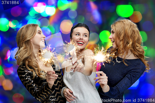 Image of happy young women with sparklers over lights