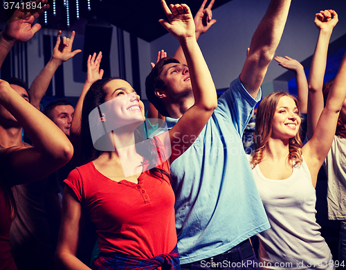 Image of smiling friends at concert in club