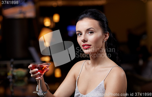 Image of glamorous woman with cocktail at night club or bar