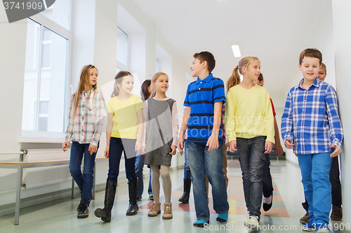 Image of group of smiling school kids walking in corridor