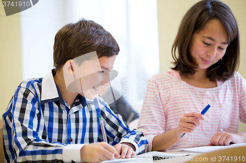 Image of group of school kids writing test in classroom