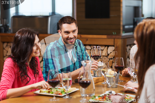 Image of friends dining and drinking wine at restaurant