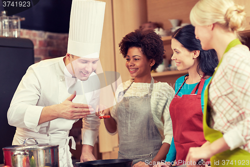 Image of happy women and chef cook cooking in kitchen