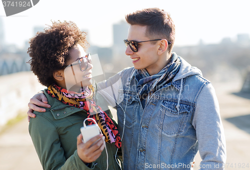 Image of smiling couple with smartphone and earphones