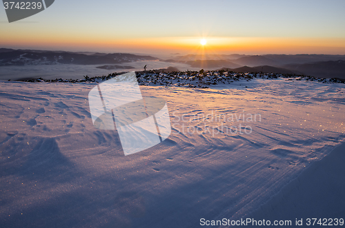 Image of Winter sunrise over frozen landscape