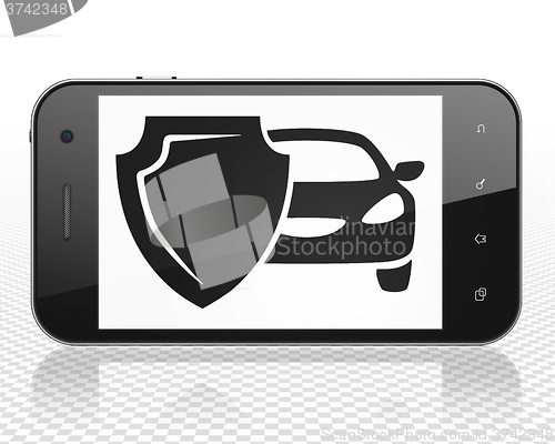 Image of Insurance concept: Smartphone with Car And Shield on display