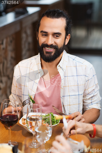 Image of happy man having dinner at restaurant