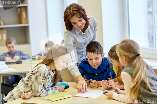 Image of group of school kids writing test in classroom