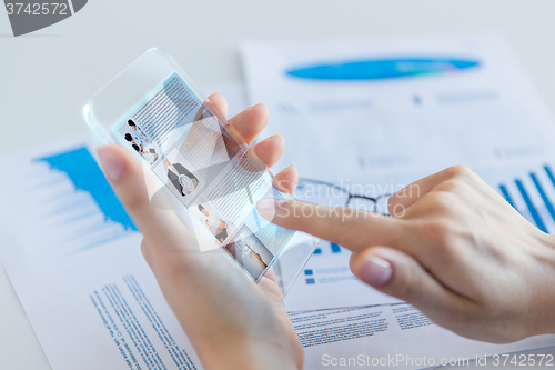 Image of close up of woman with transparent smartphone