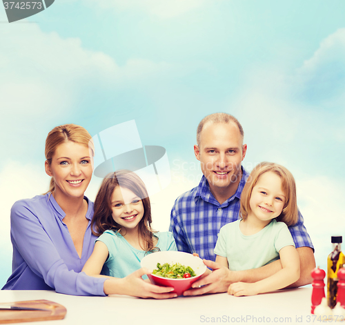 Image of happy family with two kids with salad at home