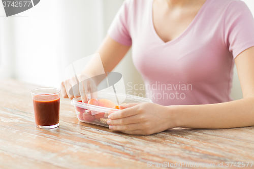 Image of close up of woman with food in plastic container