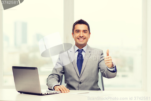 Image of businessman working with laptop in office