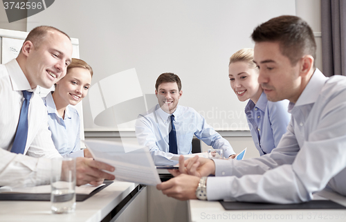 Image of group of smiling businesspeople meeting in office