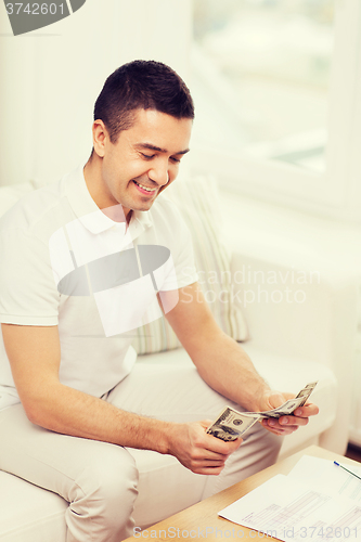 Image of man with papers and calculator at home