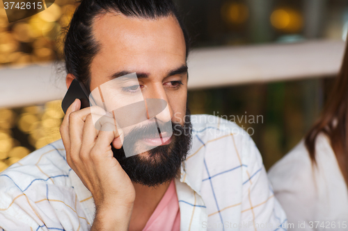 Image of sad man calling on smartphone at restaurant