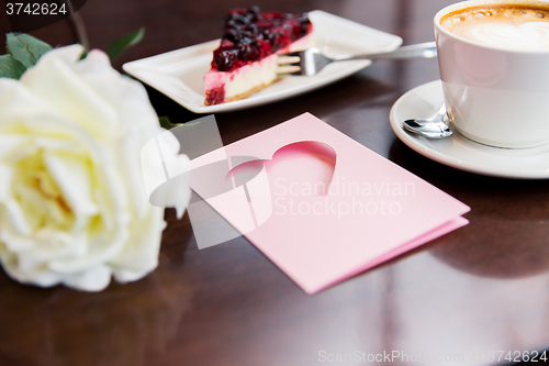 Image of close up of greeting card with heart and coffee