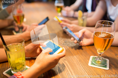 Image of close up of hands with smartphones at restaurant