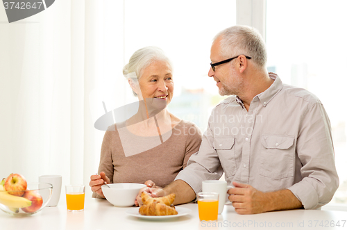 Image of happy senior couple having breakfast at home