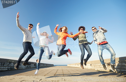 Image of smiling friends in sunglasses laughing on street