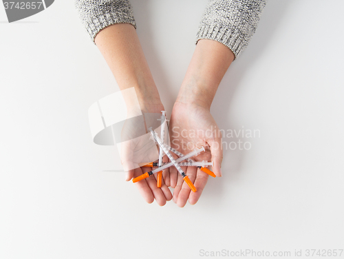 Image of close up of woman hands holding syringes