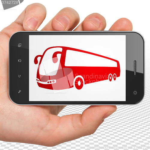 Image of Travel concept: Hand Holding Smartphone with Bus on display