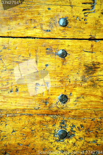 Image of metal nail dirty  yellow  stripped paint in the brown    