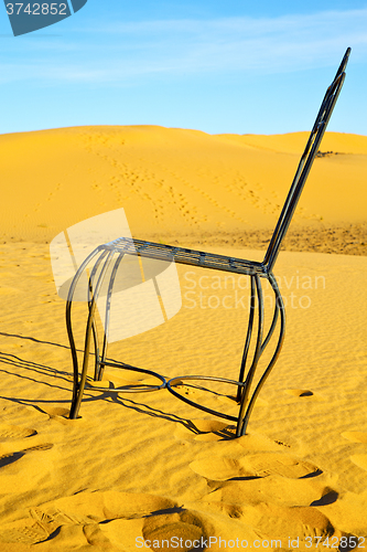 Image of table and seat in desert    yellow sand