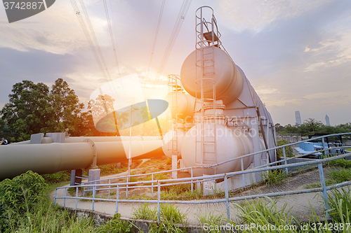 Image of Oil and gas industry refinery factory at sunset